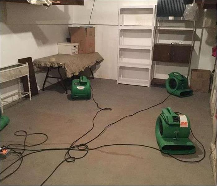three air movers drying out a room with a bookcase and small table and shelving